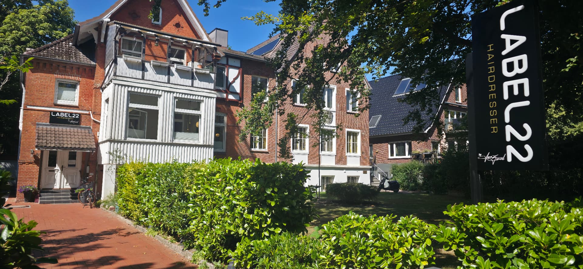 Außenansicht der LABEL22 Villa mit Salonschild in Kiel-Düsternbrook